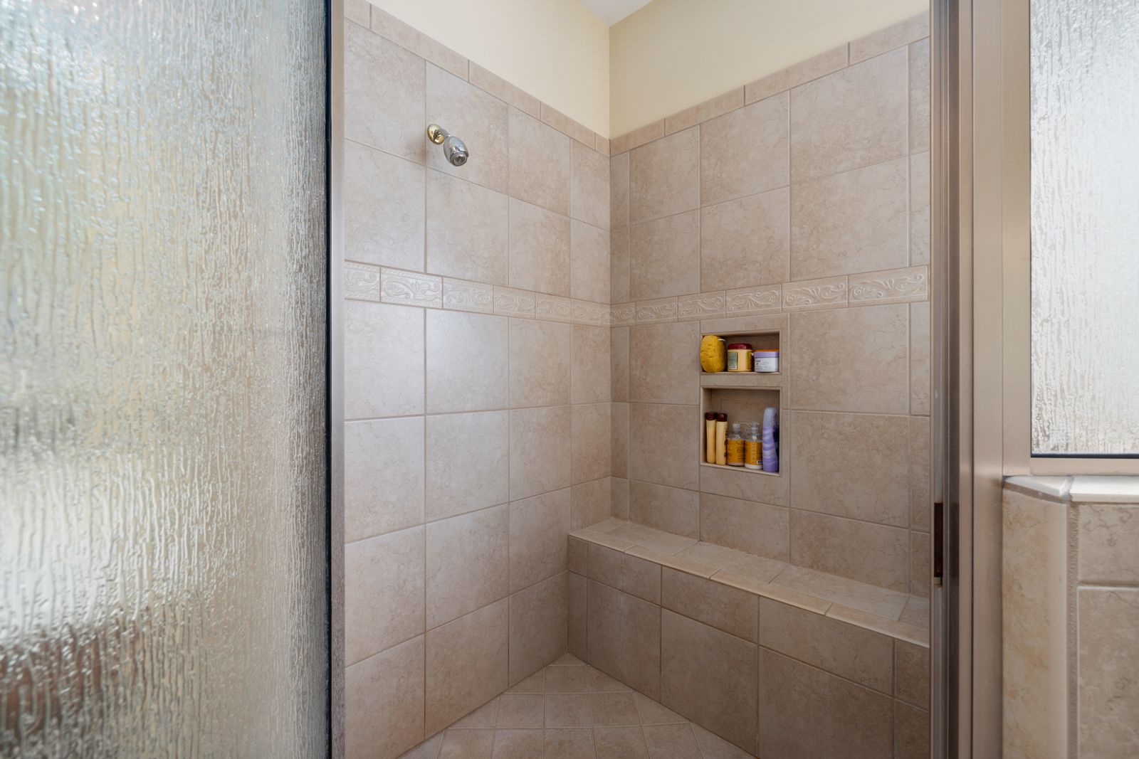 Sample image of a walk-in shower with beige tiles and a tiled bench